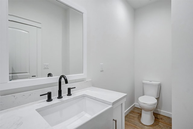 bathroom featuring hardwood / wood-style floors, vanity, and toilet