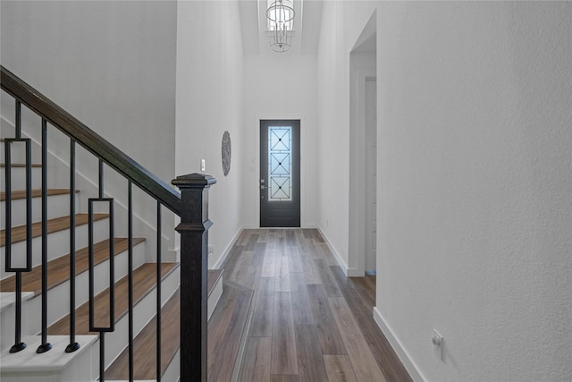 entrance foyer featuring a chandelier, a high ceiling, and hardwood / wood-style flooring