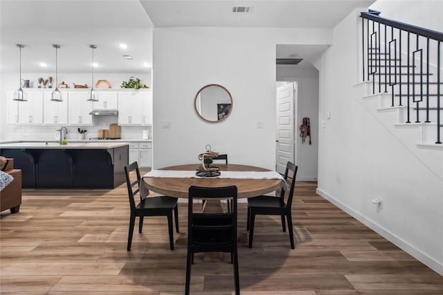 dining space with wood-type flooring and sink