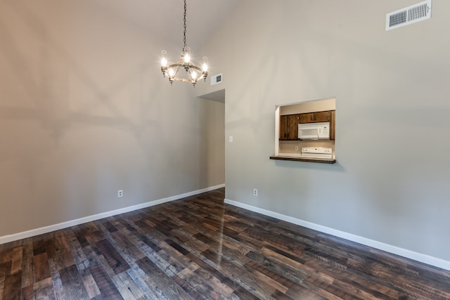 empty room featuring high vaulted ceiling, a chandelier, and dark hardwood / wood-style flooring