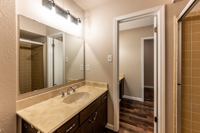 bathroom with vanity, an enclosed shower, and wood-type flooring