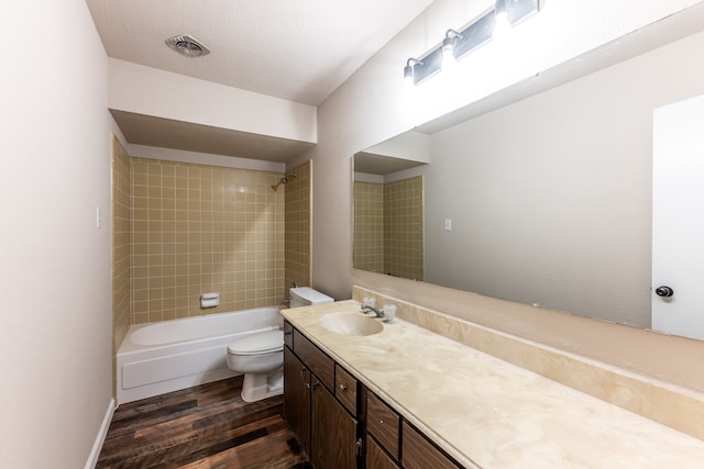 full bathroom with wood-type flooring, toilet, vanity, and tiled shower / bath