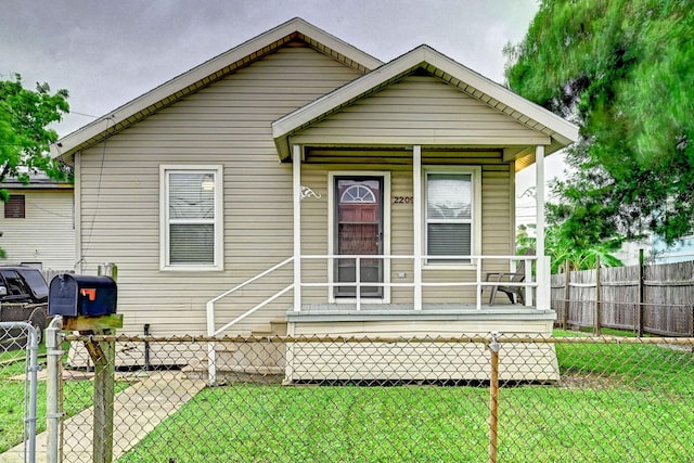 bungalow-style home with covered porch and a front lawn