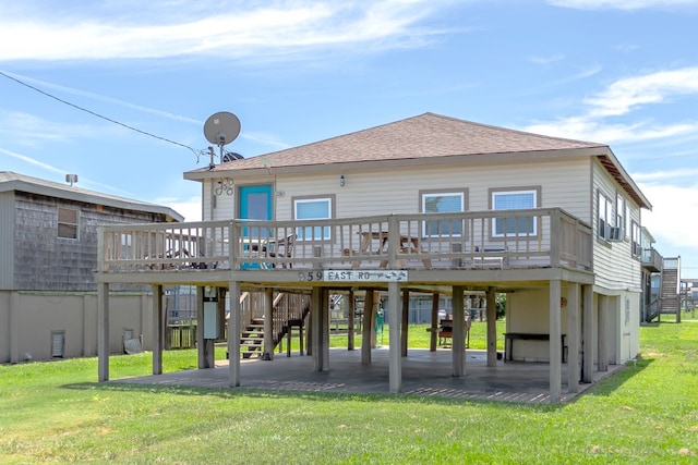 back of property with a wooden deck, a patio, and a lawn