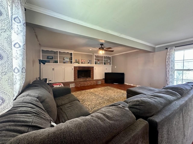 living room with a brick fireplace, crown molding, hardwood / wood-style floors, and ceiling fan