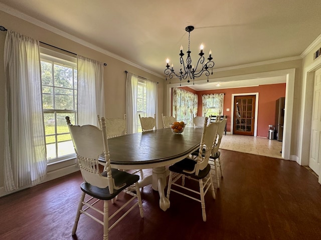 dining area with a wealth of natural light, hardwood / wood-style floors, a chandelier, and ornamental molding