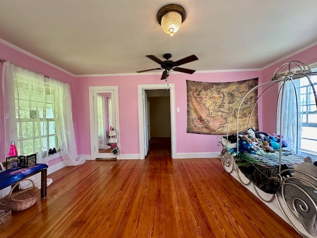 bedroom featuring hardwood / wood-style floors, ceiling fan, and multiple windows