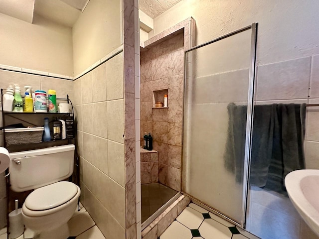 bathroom with tile walls, toilet, and tiled shower