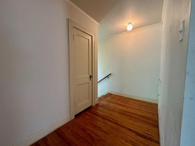 corridor with dark hardwood / wood-style flooring and ornamental molding