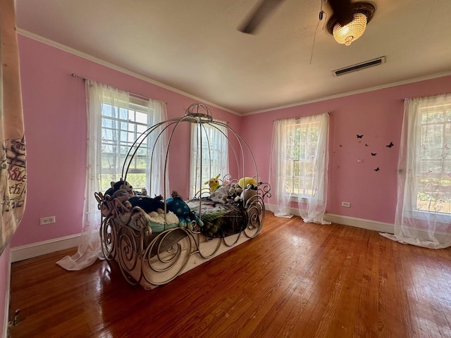 misc room with ornamental molding, wood-type flooring, and a wealth of natural light