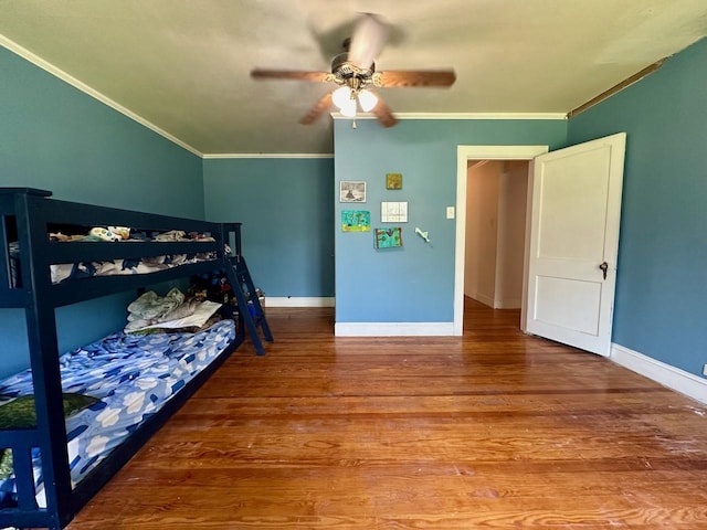 bedroom with hardwood / wood-style flooring, ornamental molding, and ceiling fan