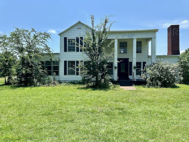 view of front of house with a front yard and covered porch