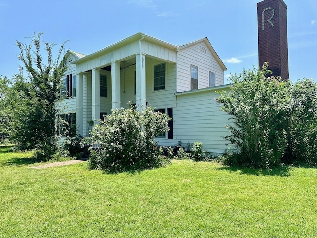 view of side of home with a yard