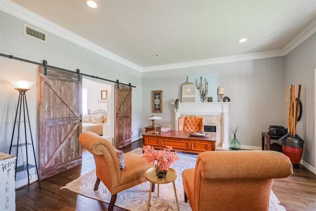 living room featuring a barn door, crown molding, and hardwood / wood-style flooring