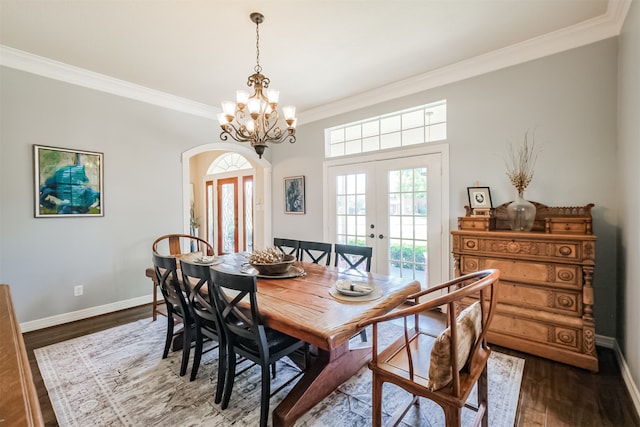 dining room with dark hardwood / wood-style floors, ornamental molding, french doors, and a chandelier