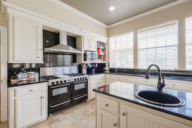 kitchen featuring range with two ovens, wall chimney exhaust hood, sink, tasteful backsplash, and light tile floors