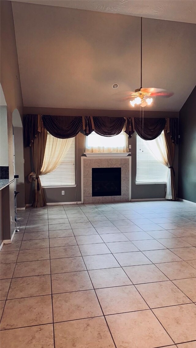 unfurnished living room with tile flooring, a tiled fireplace, and a wealth of natural light