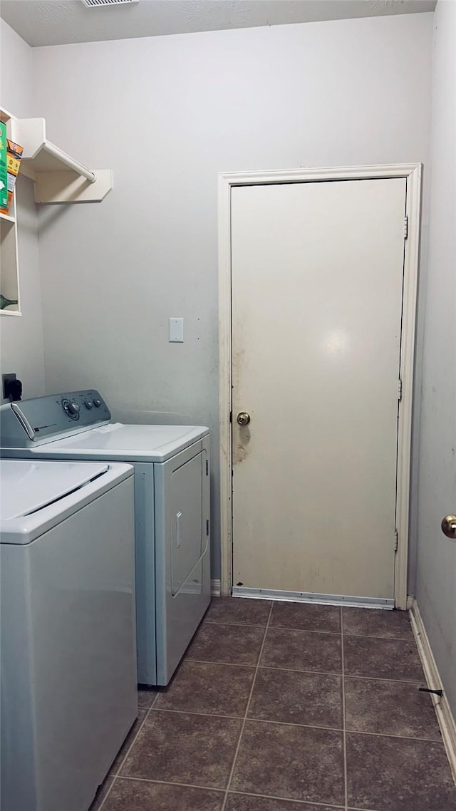 washroom with washing machine and dryer, dark tile flooring, and hookup for an electric dryer