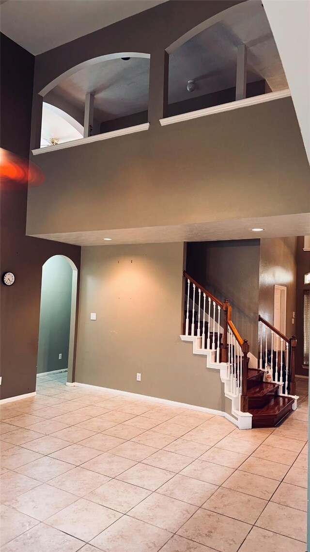 interior space with tile floors and a towering ceiling