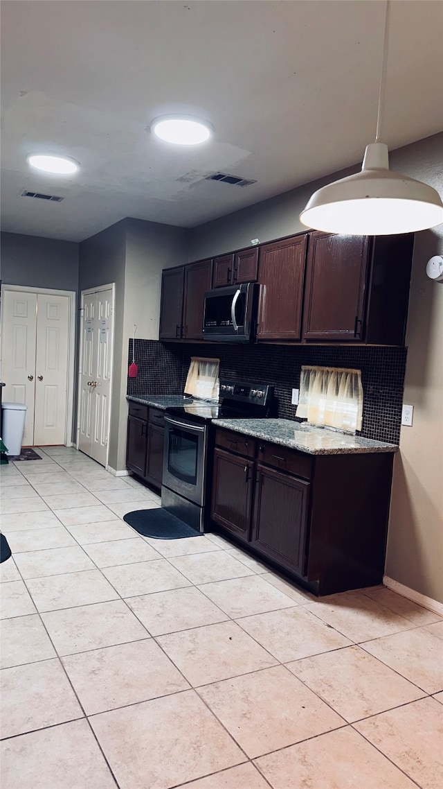 kitchen featuring light stone countertops, appliances with stainless steel finishes, dark brown cabinetry, tasteful backsplash, and light tile floors