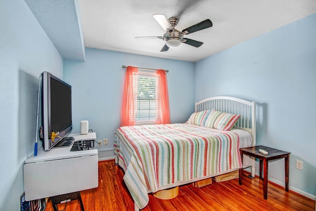 bedroom with ceiling fan and dark hardwood / wood-style flooring