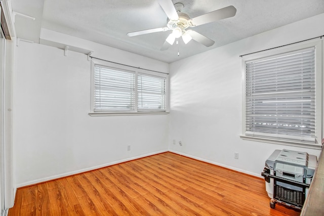 spare room with ceiling fan and light wood-type flooring