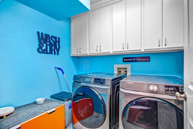 washroom with cabinets and washing machine and clothes dryer