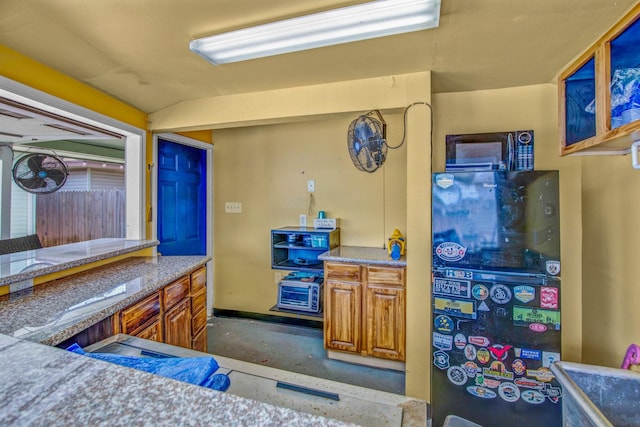 kitchen featuring light stone counters and concrete flooring