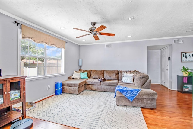 living room with ceiling fan, ornamental molding, and hardwood / wood-style floors