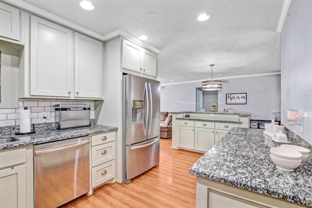 kitchen with decorative backsplash, stainless steel appliances, light hardwood / wood-style floors, and ornamental molding