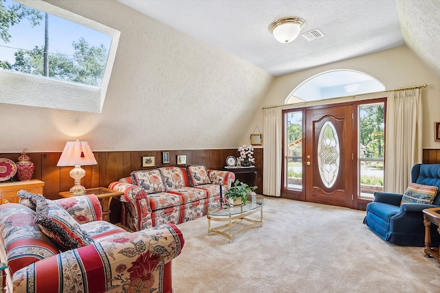 living room with vaulted ceiling, wood walls, a textured ceiling, and carpet floors