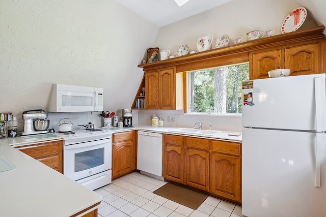 kitchen with sink, tasteful backsplash, white appliances, and vaulted ceiling