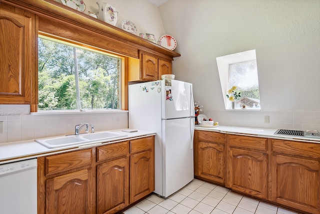 kitchen with white appliances, sink, tasteful backsplash, and light tile floors