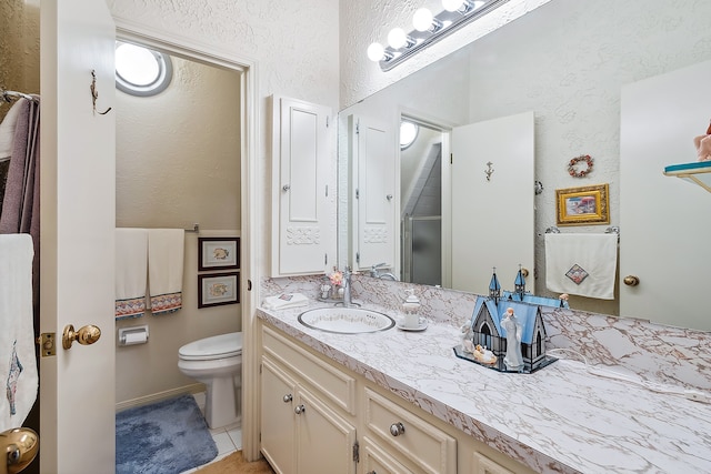 bathroom with vanity with extensive cabinet space, toilet, and tile floors