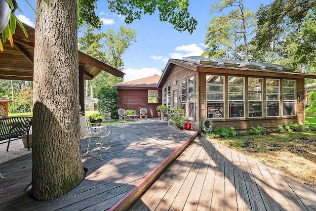 wooden deck with a sunroom