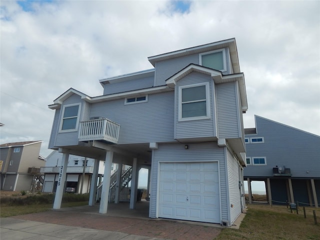 coastal inspired home with a garage and a balcony