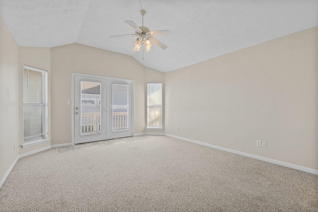 spare room with ceiling fan, a textured ceiling, light colored carpet, and lofted ceiling