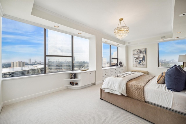 carpeted bedroom featuring a chandelier, a tray ceiling, and ornamental molding