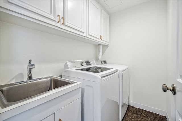 washroom featuring washer and dryer, cabinets, and sink