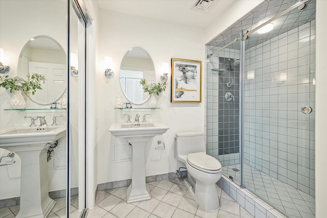 bathroom with tile patterned floors, toilet, and walk in shower