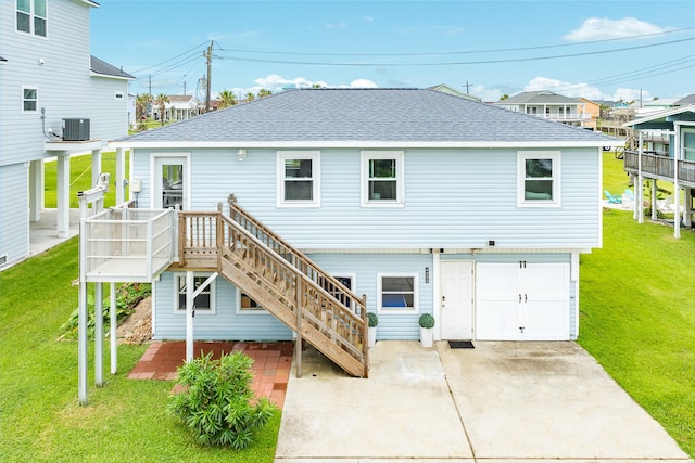 rear view of house with a yard, central AC, a garage, and a wooden deck