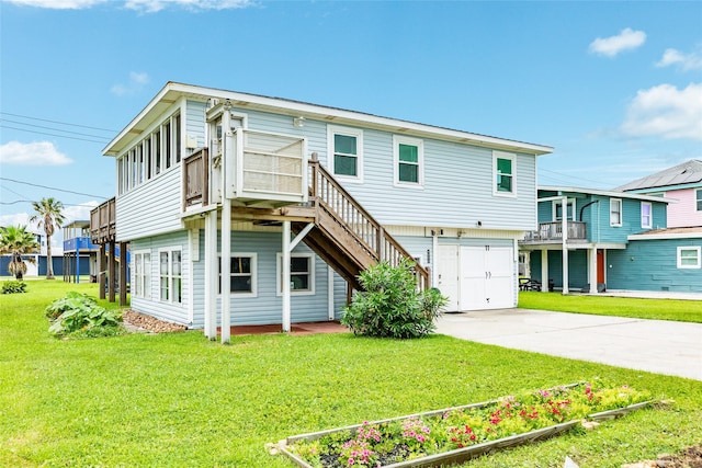 view of front of home with a deck, an attached garage, stairs, concrete driveway, and a front lawn