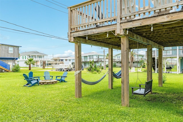 view of play area with an outdoor fire pit, a lawn, and a residential view