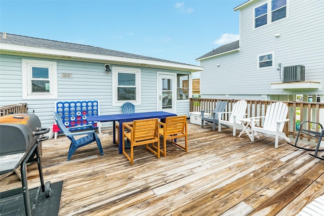 wooden deck with central AC unit and outdoor dining space