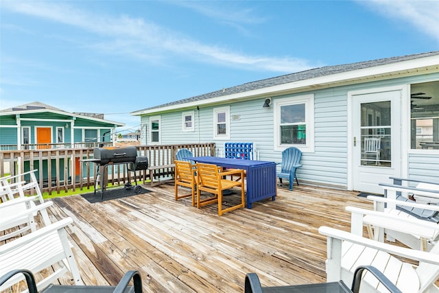 deck featuring outdoor dining space and grilling area