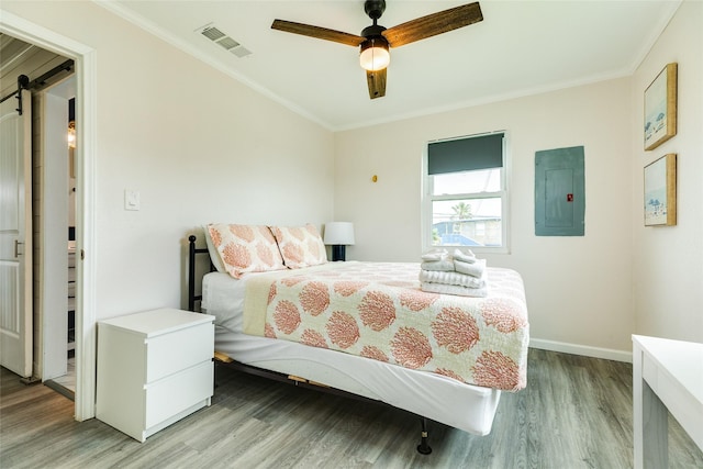 bedroom with electric panel, baseboards, visible vents, ornamental molding, and light wood-style floors