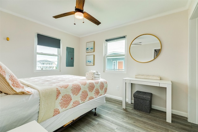 bedroom with electric panel, crown molding, baseboards, and wood finished floors