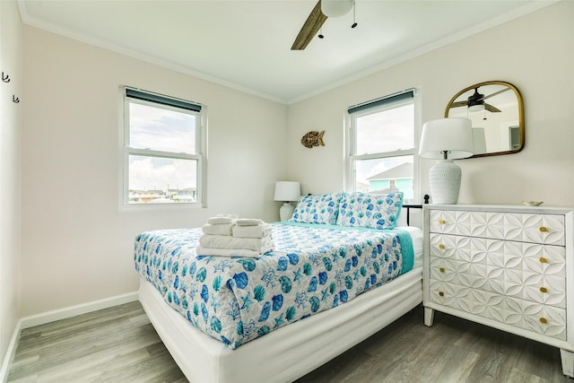 bedroom with ornamental molding, multiple windows, and wood finished floors