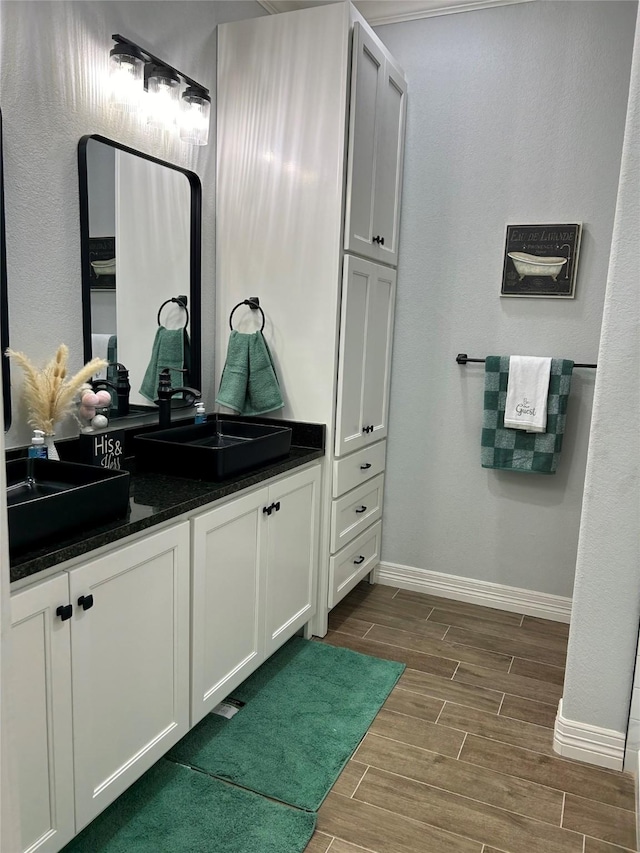 129 S Grace St, Crockett, TX 75835 - bathroom featuring wood tiled floors, baseboards, and vanity