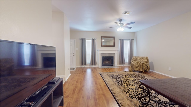 living room with ceiling fan and light hardwood / wood-style flooring